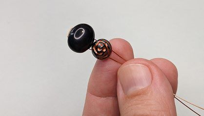 Black and rose beads with folded wire threaded through them